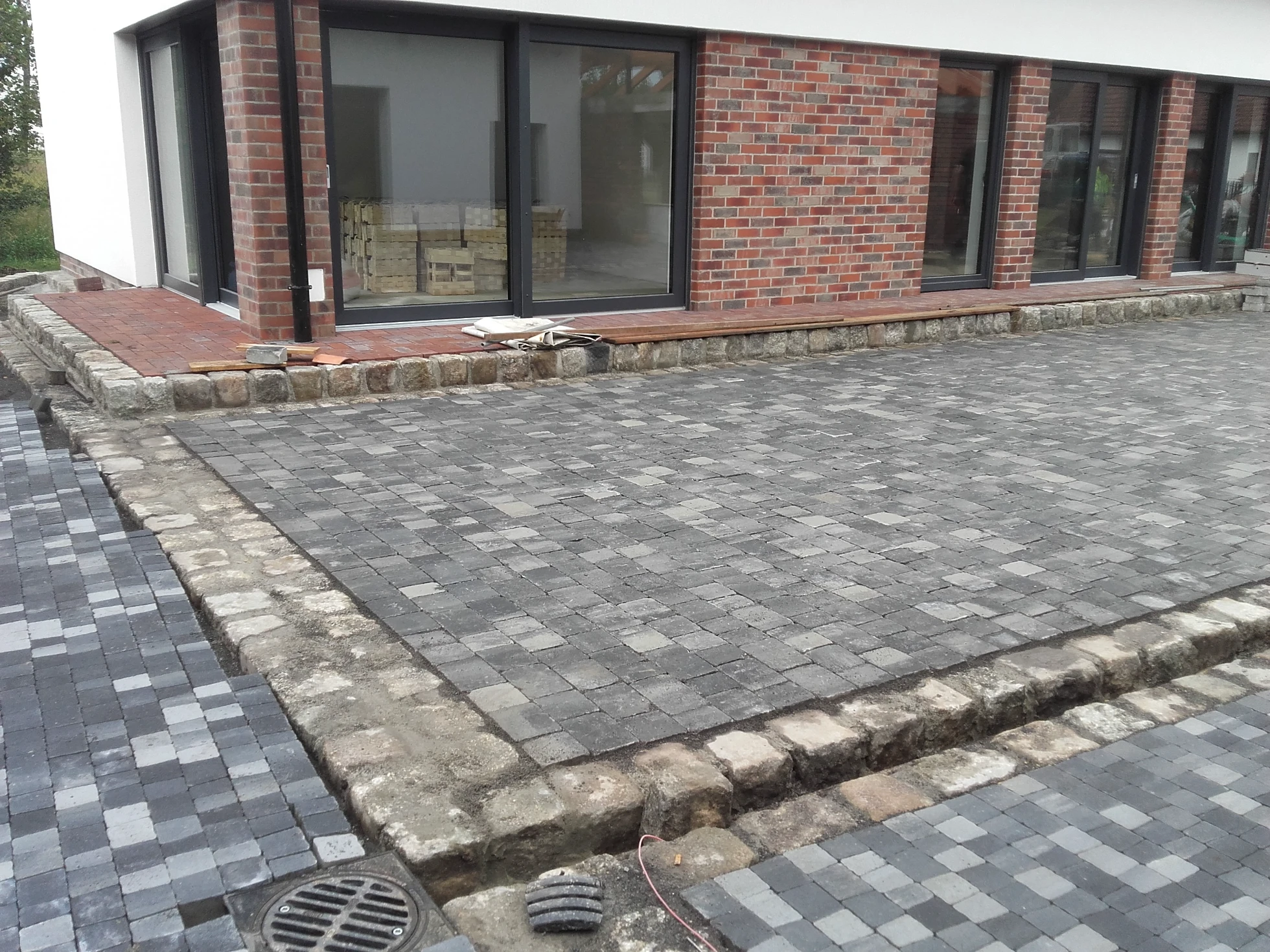 Układanie kostki brukowej szara nawierzchnia z kostki brukowej przed nowoczesnym budynkiem